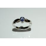 A Tanzanite and diamond ring, central teardrop tanzanite collet set,