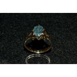 A green/blue stone dress ring, single oval stone possibly a spinel, yellow metal shank, size N, 2.