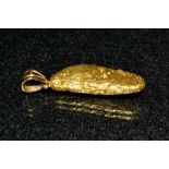 An Australian gold nugget pendant, natural form yellow metal kidney shaped nugget,