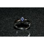 A Tanzanite and diamond ring, central teardrop tanzanite collet set,