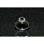 A spinel and diamond floral cluster ring, central round cut blue spinel,