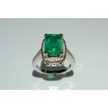 An emerald and diamond ring, central rectangular baguette emerald approx 5ct ,