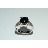 A black and white diamond ring, central circular black diamond approx 2.