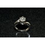 A diamond cluster ring, central round crest of seven round brilliant cut diamonds,