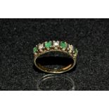 A diamond and emerald seven stone 1/2 eternity ring,