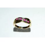 A ruby and diamond crossover ring, inset with four ruby's and three diamond accents, 9ct gold shank,