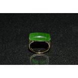 A green jade signet ring, domed rectangular jade cabochon sunken into an 8ct gold shank,