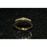 A diamond half eternity ring, channel set with nine round brilliant cut diamonds,