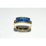 A vibrant blue six stone dress ring, liner inset with six baguettes, 14ct gold shank, stamped 585,