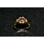 A ruby and diamond ring, central oval deep red ruby,