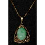 An Art Nouveau stained jade mounted pendant, oval jade cabochon,