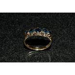 A blue spinel five stone ring, linear set with five graduated round and ellipse cut blue spinels,