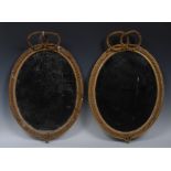 A pair of 19th century giltwood and gesso oval looking glasses,