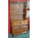 An Old Charm oak dresser, outswept cornice, shaped apron, acorn underfinials over two shelves,