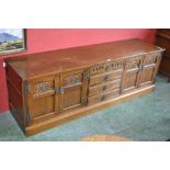 An oak Old Charm low sideboard, four drawers flanked by two door cupboards, plinth base.