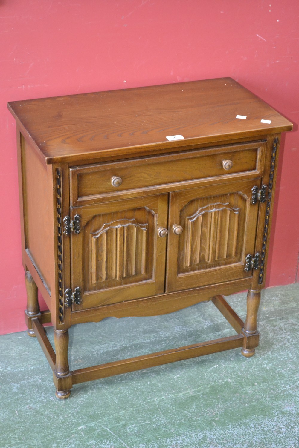 A Nathan furniture side cabinet, single drawer over two linen fold door cupboards,