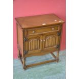 A Nathan furniture side cabinet, single drawer over two linen fold door cupboards,