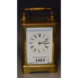 A lacquered brass five panel carriage clock, bevelled panels, swing handle, white enamel dial,