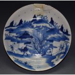 An 18th century circular dish, decorated in underglaze blue with bull, keeper, huts, mountains,