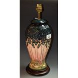 A Moorcroft pottery lamp base, Stylised Trees design, wooden base,