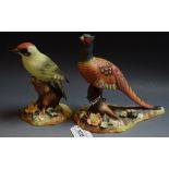 Derby - a figure of a green woodpecker resting on a tree stump, raised dog rose decoration,