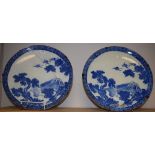 A pair of Japanese circular chargers, decorated in underglaze blue with three cranes, in flight,