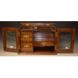 An oak tobacco cabinet with labelled card drawer, two other drawers,