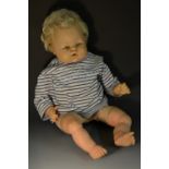 A clock work wind up plastic head baby doll, open mouth, painted fixed blue eyes, blond hair,