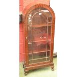 An Art Deco dome top cabinet, astragal glazed door, ball and claw feet,