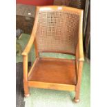 An oak Arts and Crafts open arm chair, canework back.