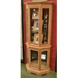 A modern limed oak display cabinet, stepped cornice, canted angles,