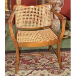 A small ash open arm chair, canework back and seat.