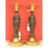 A pair of Grecian Revival dark and gilt patinated bronze figural candlesticks,