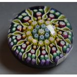 A Scottish Perthshire glass millefiori paperweight, spiralled and multi-coloured canes,