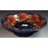 A Moorcroft Pomegranate pattern flared cylindrical pedestal bowl, tube lined with whole fruit,