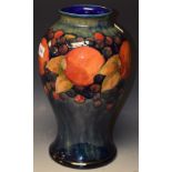 A Moorcroft Pomegranate pattern baluster vase, tube lined with large fruit and berries, 34cm high,