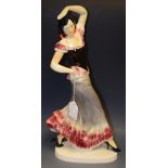 A large continental earthenware model of a Flamenco Dancer, glazed in glossy tones of pink, grey,