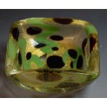 A Studio glass rounded square dish, inset with gold green and black roundel's and irregular lines,