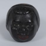 An early 20th century pottery money bank, as a black boy's head,