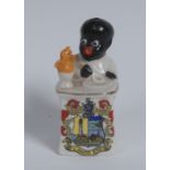 An Arcadian China Crested Ware model, of a young black boy seated at a table,