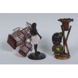 An early 20th century painted spelter novelty figural candlestick, cast as a young black schoolboy,