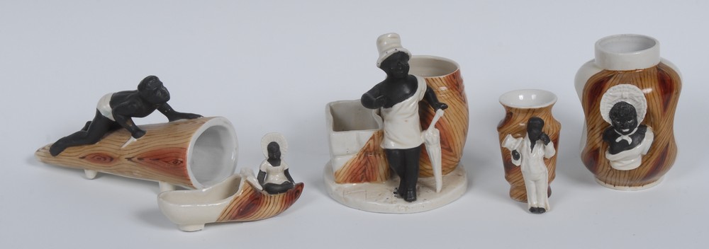 An early 20th century spill vase, moulded with a black boy, holding an umbrella,