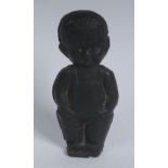 An early 20th century black rubber model, of a young black boy wearing dungarees,