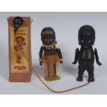 A mid 20th century clockwork toy, as a dancing native, 14cm high; a wooden doll,