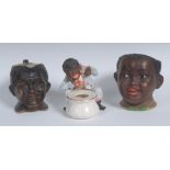 A Continental porcelain novelty inkwell, modelled as a comical black man beside a pot,