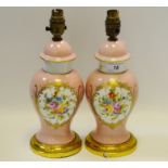 A pair of baluster shaped lamp bases painted with floral motif on a pink ground