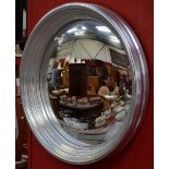 A large convex wall mirror with silver coloured frame. 85cm outside diameter.