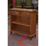 A reproduction teak floor standing bookcase, two short drawers over shelving, ogee feet.