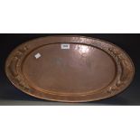 A copper Arts and Crafts two handled oval tray, embossed with leafy heart motifs,