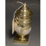 A silver neo-classical style pepper pot, spire finial, square base, London 1914,